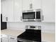 Close-up view of the kitchen's stainless steel microwave and electric range cooktop at 2961 Gavin Sky Dr, Kissimmee, FL 34744