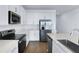 Modern white kitchen featuring an island with quartz countertops, stainless steel appliances, and wood-look tile flooring at 2967 Gavin Sky Dr, Kissimmee, FL 34744