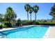 Beautiful community pool area surrounded by palm trees and lounge chairs at 300 Falling Water Dr, Kissimmee, FL 34759