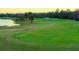 Scenic golf course view featuring lush green fairways and mature trees with a serene lake in the background at 300 Falling Water Dr, Kissimmee, FL 34759