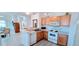 Bright kitchen featuring an open layout, white appliances, and a breakfast bar area at 300 Falling Water Dr, Kissimmee, FL 34759