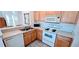 Bright kitchen featuring wood cabinets, stainless steel sink, and white appliances at 300 Falling Water Dr, Kissimmee, FL 34759