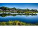 Picturesque view of homes reflected in a tranquil lake surrounded by lush greenery, serene community setting at 300 Falling Water Dr, Kissimmee, FL 34759
