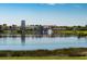 Expansive lake view with reflections of community buildings, palm trees, and landscaping, serene living at 300 Falling Water Dr, Kissimmee, FL 34759