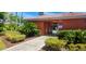 Exterior view of the community pool house with lush landscaping and sidewalk at 300 Falling Water Dr, Kissimmee, FL 34759