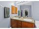 Bathroom featuring a double sink vanity, granite countertop and a large mirror, offering ample space and functionality at 323 Azincourt Ln, Kissimmee, FL 34759