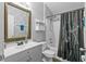 Bathroom featuring a vanity with granite countertop, shower-tub combo with decorative shower curtain at 323 Azincourt Ln, Kissimmee, FL 34759