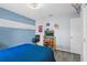 Comfortable bedroom with blue walls, TV on shelves, and sports decor at 323 Azincourt Ln, Kissimmee, FL 34759
