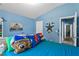 Bedroom with blue walls with cartoon character pillows on the bed with decor on the walls and doors to adjacent rooms at 323 Azincourt Ln, Kissimmee, FL 34759