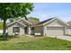 Charming single-story home with a well-manicured lawn and a two-car garage during daylight at 323 Azincourt Ln, Kissimmee, FL 34759