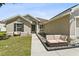 Charming single-story home with a well-manicured lawn and a seating area at the front entrance at 323 Azincourt Ln, Kissimmee, FL 34759