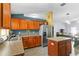 Kitchen area equipped with wood cabinets, stainless steel refrigerator, and center island, open to dining area at 323 Azincourt Ln, Kissimmee, FL 34759