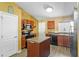 Well-lit kitchen showcasing wood cabinets, black appliances, and a functional center island at 323 Azincourt Ln, Kissimmee, FL 34759