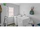 Laundry room featuring a washing machine, dryer and window for natural light with storage shelves above at 323 Azincourt Ln, Kissimmee, FL 34759