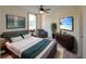 Comfortable bedroom featuring a ceiling fan, large television, cozy chair, and stylish decor at 3245 Heirloom Rose Pl, Oviedo, FL 32766