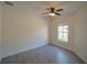 This cozy bedroom features a ceiling fan, a neutral color palette, and a large window at 3245 Heirloom Rose Pl, Oviedo, FL 32766
