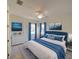 Serene bedroom featuring a tufted headboard, matching blue decor, and an abundance of natural light at 3245 Heirloom Rose Pl, Oviedo, FL 32766