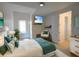 Bright bedroom with a mounted TV, comfy chair, and natural light coming from the window at 3245 Heirloom Rose Pl, Oviedo, FL 32766