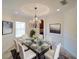 Elegant dining room with a glass table, seating for six, and a stylish chandelier at 3245 Heirloom Rose Pl, Oviedo, FL 32766