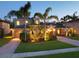 Charming two-story home with lush landscaping, a brick driveway, and a well-lit front yard at dusk at 3245 Heirloom Rose Pl, Oviedo, FL 32766