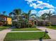 A beautiful home with a manicured lawn, colorful flowers, and stately palm trees at 3245 Heirloom Rose Pl, Oviedo, FL 32766