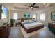 Bright main bedroom featuring a tray ceiling, ceiling fan, and a large window with natural light at 3245 Heirloom Rose Pl, Oviedo, FL 32766