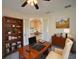Inviting home office featuring a large desk, ample shelving, and view to the living room at 3245 Heirloom Rose Pl, Oviedo, FL 32766