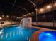 Enclosed pool area with waterfall feature, hot tub, outdoor lighting, and privacy fence at 3245 Heirloom Rose Pl, Oviedo, FL 32766