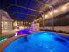 Stunning pool featuring a cascading waterfall, ambient lighting, and a screened enclosure for year-round enjoyment at 3245 Heirloom Rose Pl, Oviedo, FL 32766