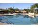 Resort-style pool with sunshades, palm trees, and a building in the background on a sunny day at 3245 Heirloom Rose Pl, Oviedo, FL 32766