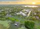 Beautiful sunset aerial view of the community nestled amongst lush greenery near a tranquil lake and dock at 333 Lake Howard Dr Nw # 204D, Winter Haven, FL 33880