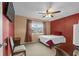 Inviting bedroom with red accent wall, ceiling fan, and comfortable single bed at 333 Lake Howard Dr Nw # 204D, Winter Haven, FL 33880