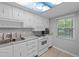 Clean kitchen with white cabinets, tile floors, and a window providing natural light at 333 Lake Howard Dr Nw # 204D, Winter Haven, FL 33880