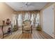Cozy living room featuring an ornate chair, decorative vases, and stylish window treatments at 333 Lake Howard Dr Nw # 204D, Winter Haven, FL 33880