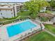 Aerial view of a community pool with plenty of seating and lush greenery in a quiet neighborhood at 333 Lake Howard Dr Nw # 204D, Winter Haven, FL 33880