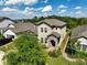 Scenic aerial view of a home with lush landscaping, a brick-paved driveway, and mature trees at 3447 Feathergrass Ct, Harmony, FL 34773