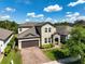 Beautiful home with lush green landscaping, a paver driveway, and a two-car garage at 3447 Feathergrass Ct, Harmony, FL 34773