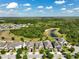 Expansive aerial view of a residential neighborhood with a pond and lush green spaces at 3447 Feathergrass Ct, Harmony, FL 34773
