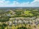 Picturesque aerial view of homes with well-maintained yards bordering a wooded area under a blue sky at 3447 Feathergrass Ct, Harmony, FL 34773