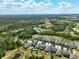 Beautiful aerial view of community homes nestled beside ponds and verdant green space beneath a sunny, cloud-flecked sky at 3447 Feathergrass Ct, Harmony, FL 34773