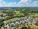 Stunning aerial view of a community near a lush golf course and lakes under a beautiful blue and cloudy sky at 3447 Feathergrass Ct, Harmony, FL 34773
