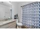 Well-lit bathroom with vanity, toilet, shower with curtain, and ample storage space at 3447 Feathergrass Ct, Harmony, FL 34773