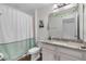 Bright bathroom featuring a granite countertop, white cabinets, shower with curtain, and wood look floor tiles at 3447 Feathergrass Ct, Harmony, FL 34773