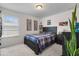 Cozy bedroom features a large window, soft carpet, and a comfortable bed with a plaid comforter at 3447 Feathergrass Ct, Harmony, FL 34773