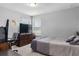 Bedroom with a large bed, dresser with a TV, and a window offering natural light at 3447 Feathergrass Ct, Harmony, FL 34773