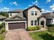 Attractive home with a stone entryway, lush landscaping, and a brick-paved driveway at 3447 Feathergrass Ct, Harmony, FL 34773