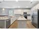 Bright kitchen with stainless steel appliances, a center island with a breakfast bar, and granite countertops at 3447 Feathergrass Ct, Harmony, FL 34773