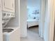Laundry area with stacked washer and dryer, leads into bedroom with white comforter at 3592 Southpointe Dr # 2, Orlando, FL 32822