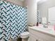 Bathroom with a tub-shower combination with stylish blue and white curtain at 372 Meadow Pointe Dr, Haines City, FL 33844