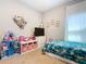 Bright bedroom with a window, toys, and a mounted television at 372 Meadow Pointe Dr, Haines City, FL 33844